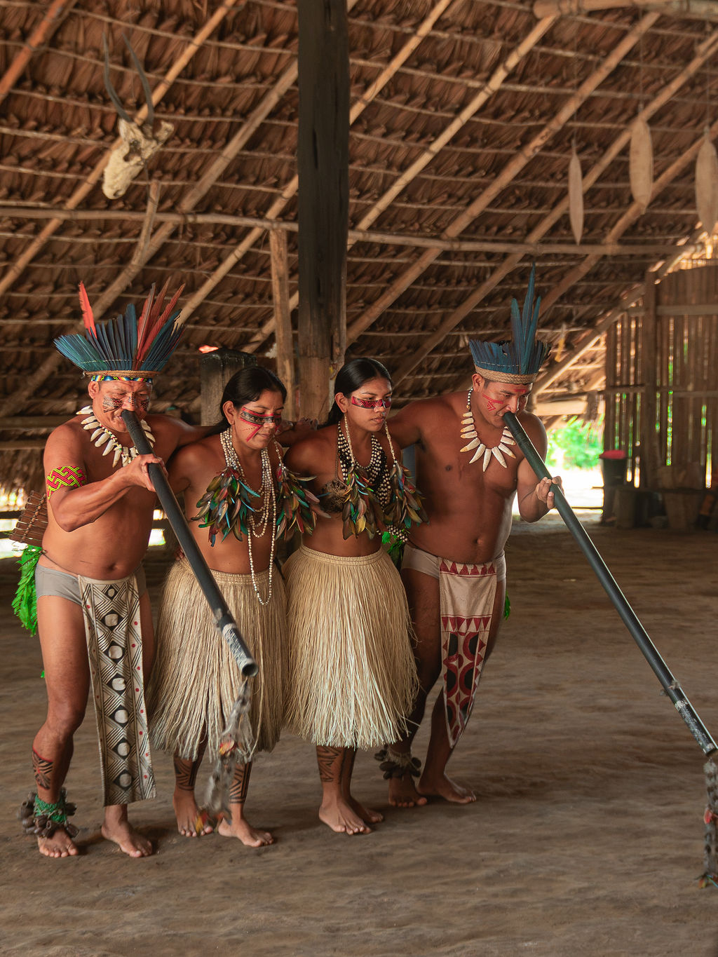 Ritual de pintura indígena no rosto de uma participante, na Amazônia